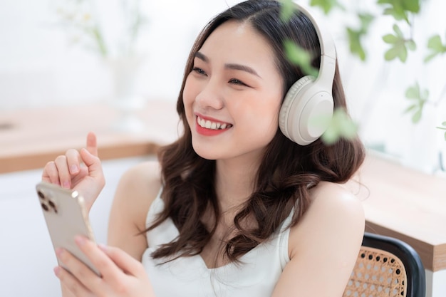 朝に家で音楽を聴いている若いアジアの女性の画像