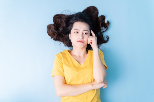 Image of young Asian woman lying on background