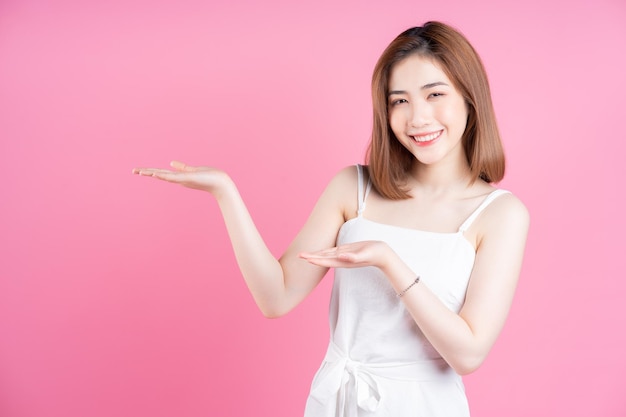 Image of young Asian woman posing on pink background