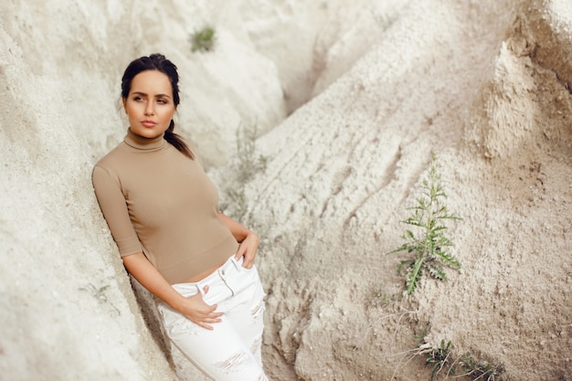 Image of a young brunette woman leaning against a wall