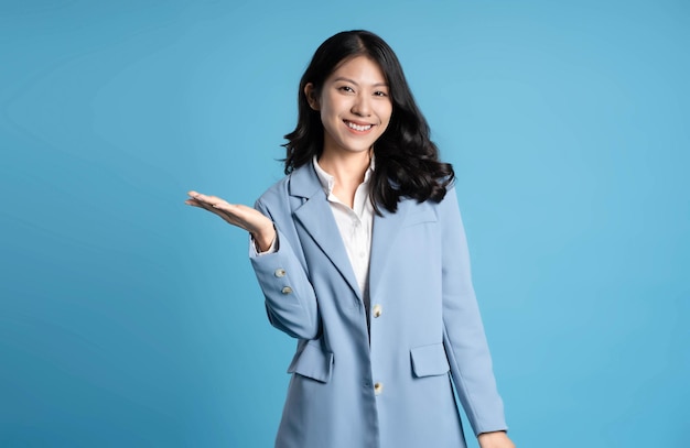 изображение молодой бизнесменки, позирующей на синем фоне