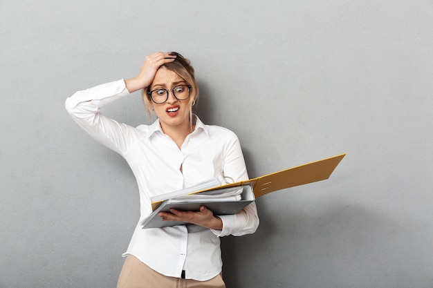 Image of a young confused business woman isolated 