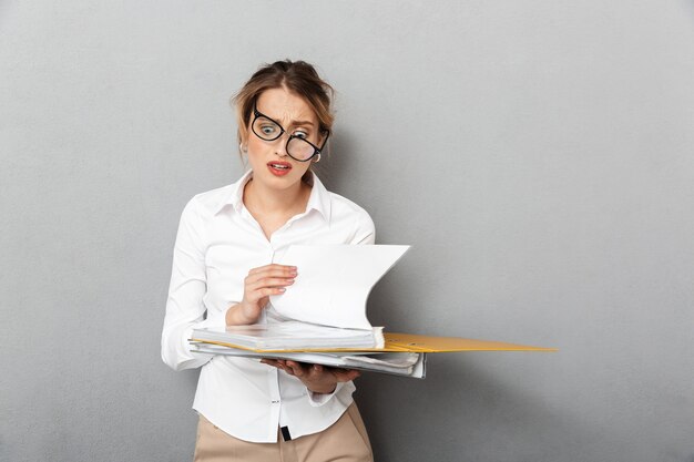 Image of a young confused business woman isolated 