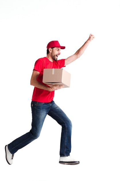 Photo image of a young delivery man walking happily with a box