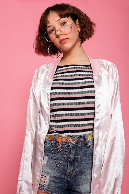 Image of young happy beautiful woman posing isolated over pink wall background. Front view of pensive pretty woman.