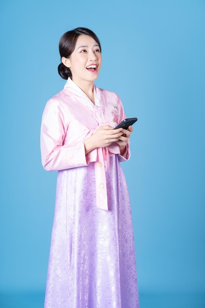 Image of young Korean woman wearing hanbok on background