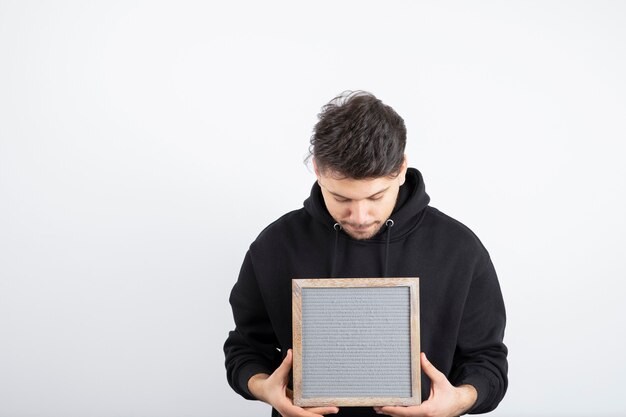 Image of young man in black hoodie showing empty frame