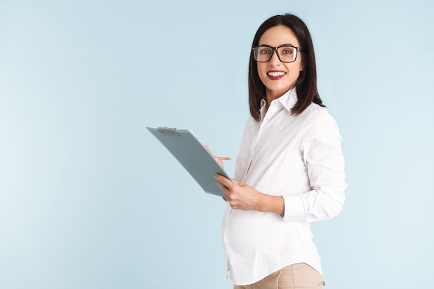 Image of a young pregnant business woman isolated holding clipboard.