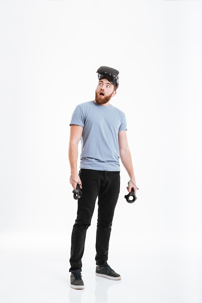 Image of young shocked man wearing virtual reality device look aside .