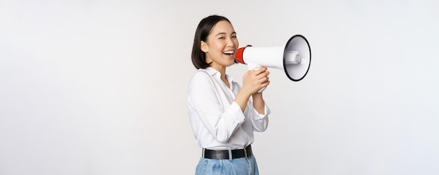 흰색 배경 위에 서 있는 확성기에서 소리를 지르는 확성기에서 비명을 지르는 젊은 여성 한국 활동가 모집자의 이미지