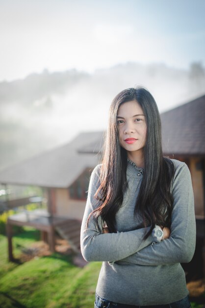 Immagini di belle donne asiatiche in piedi in belle attrazioni naturali donna asiatica con i capelli lunghi in un clima freddo e nebbioso.