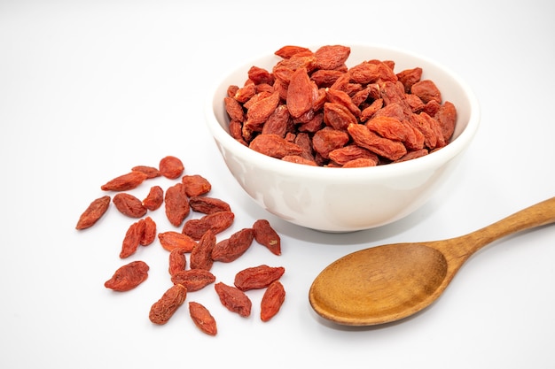 Photo images of dried goji berries in white cups and made into food on a white backgroundfractal background