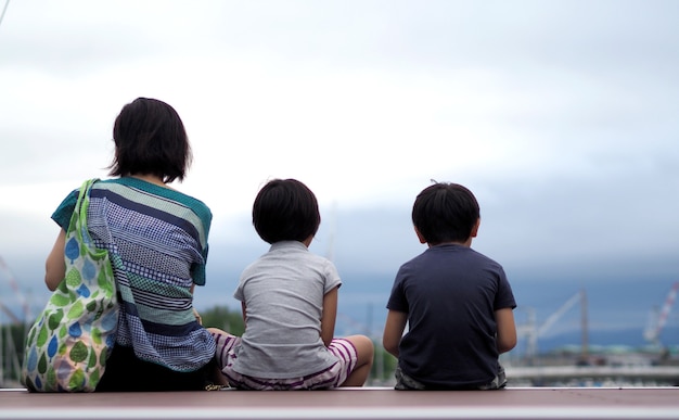 일본 홋카이도 오타루의 항구 항구나 선착장 앞에 앉아 있는 가족의 비하인드 이미지