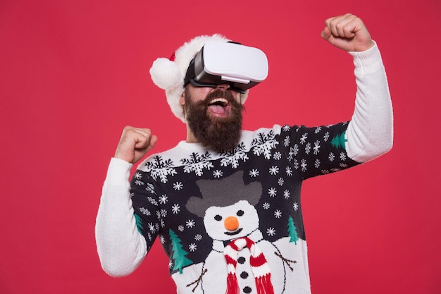 Imagine best xmas party. bearded hipster in vr glasses. man play game. winter indoor vs outdoor activity. Virtual reality. Santa virtual goggles. Happy New Year 2020 celebration holiday concept.