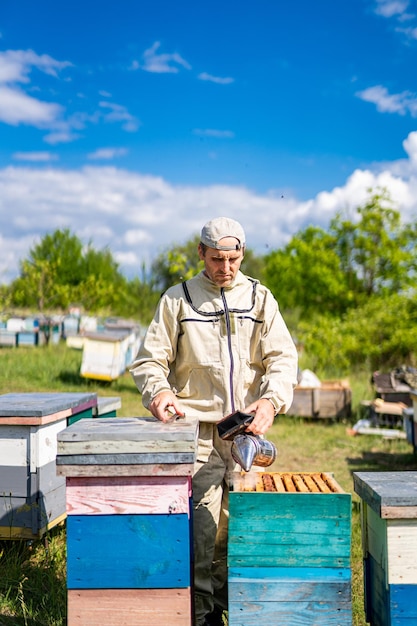 Imker aan het werk in uniform Zomerhoningraatboer