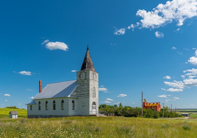 Immanuel Lutheran Church with grain elevator in the background in Admiral, Saskatchewan