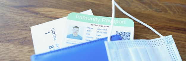 면제 여권과 비행기 티켓이있는 보호 의료 마스크가 테이블 여권에 있습니다.