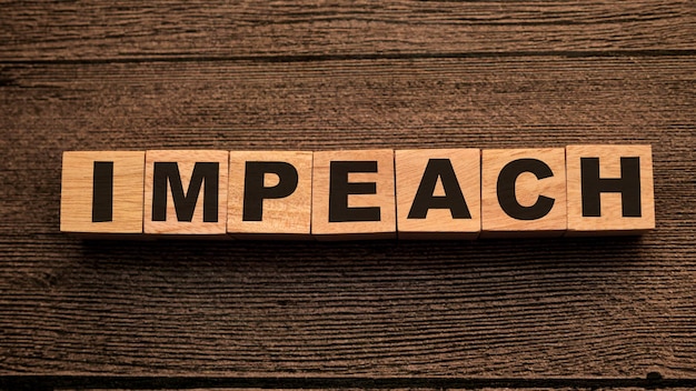 Foto impeach tekst woorden typografie geschreven op houten letters politiek en governance concept