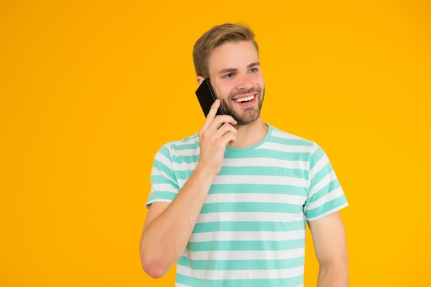 importance of being communicative happy man talk on mobile phone yellow background verbal communication mobile communication telephone communication communication technology modern life