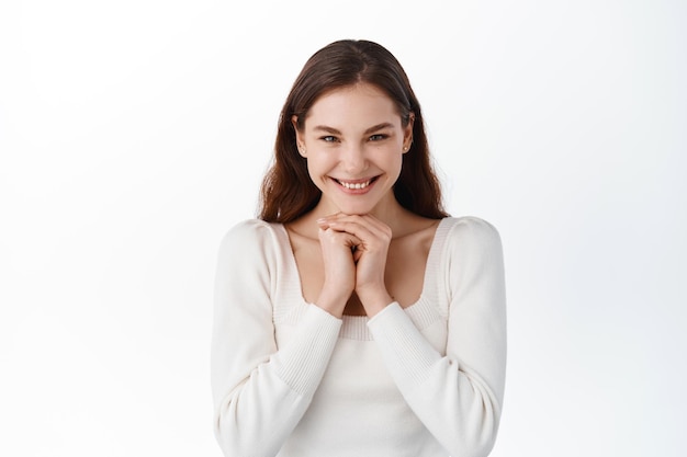 Impressed fascinated caucasian emotive enthusiastic girl, smiling astonished, hold hands face-line, stare camera excited look admiration happiness lucky news