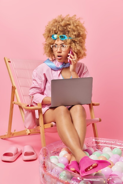 Impressed woman does remote multitasking work uses modern\
devices finds out shocking news while having phone conversation\
dressed in formal shirt with tie goggles flippers spends summer day\
at beach