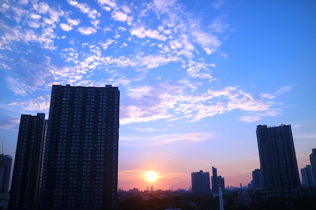 市内の高層ビル群に沈む印象的な夕日