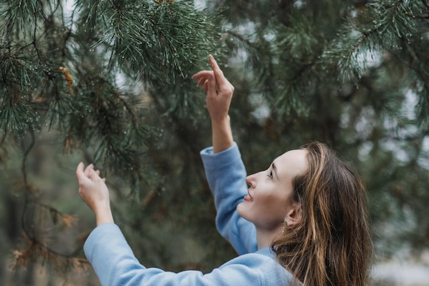 Improving mental wellbeing relax and reduce stress young woman in red sweater touching water drops