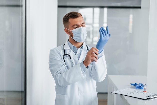 In blauwe handschoenen Professionele dokter in witte jas is in de kliniek