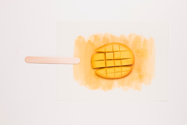 Foto in blokjes gesneden mango op waterverfplons in vorm van roomijs