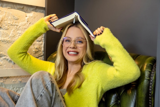 In de bibliotheek. Jonge glimlachende vrouw die de camera bekijkt