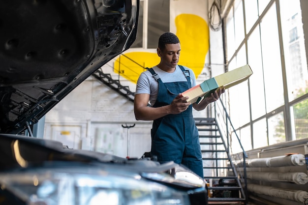 In de garage. Technicus in de garage ziet er druk en geconcentreerd uit