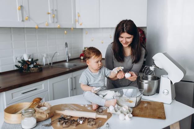 In de keuken en gelukkige familie. moeder en zoon bereiden van het deeg, koekjes bakken