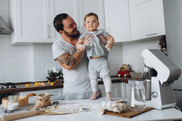 In de keuken en gelukkige familie. vader en zoon bereiden van het deeg, koekjes bakken