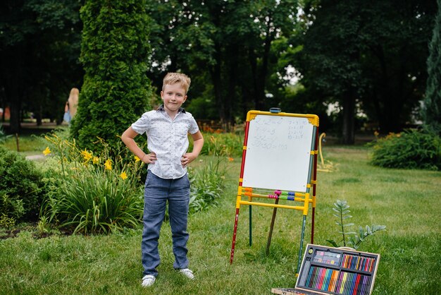 In de openlucht in het Park schrijft een student voorbeelden op het bord. Ga terug naar school, studeer tijdens de pandemie.