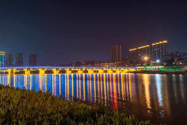 In de stad worden 's nachts kleurrijke lichten weerspiegeld in het water van de rivier