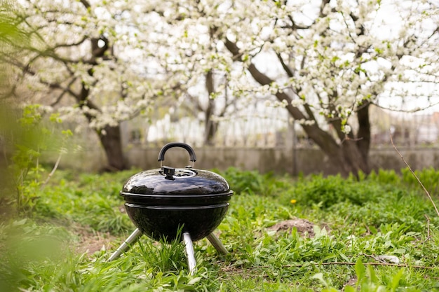 In de tuin staat een lege barbecue