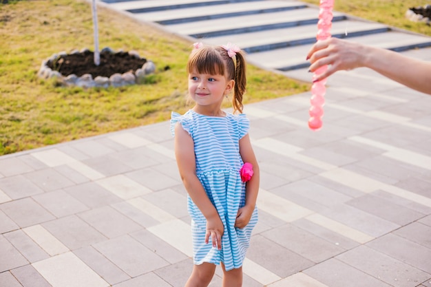 In een openbaar park blaast en vangt een klein meisje zeepbellen. Het kind speelt en lacht. De bubbels glinsteren in de zon en vliegen in verschillende richtingen.