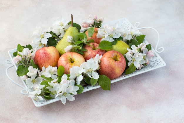 in een plaat peren, appels en bloemen van een bloeiende appelboom