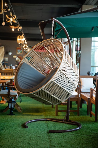 In een restaurant hangt een rotan stoel aan het plafond.