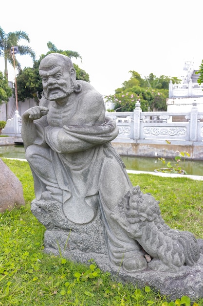 Foto in een tuin staat een standbeeld van een man.