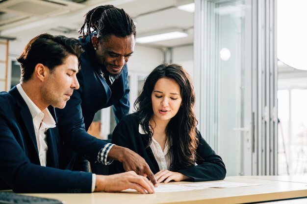 In een vergadering werken CEO en collega's samen aan onderzoeksplanning en kostenanalyse. Documenten en grafieken weerspiegelen hun toewijding aan diversiteit en teamwerk.