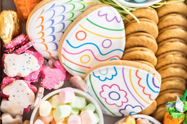 In elkaar zetten van een charcuteriebord met paassnoepjes, koekjes en marshmallows.