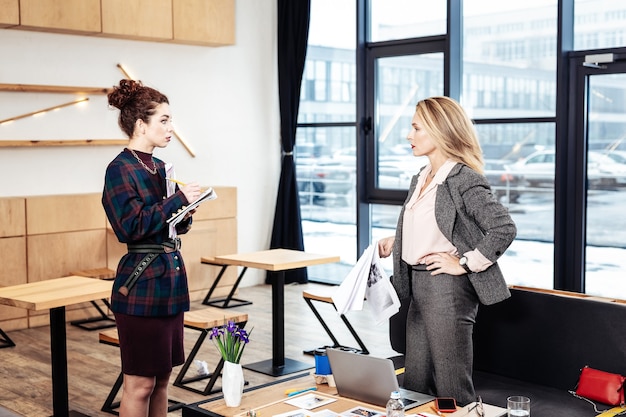 In gesprek met secretaris. Strikte ceo van internationaal bedrijf in grijs kostuum in gesprek met secretaresse