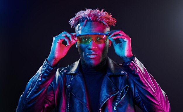 In glazen Futuristische neonverlichting Jonge Afro-Amerikaanse man in de studio