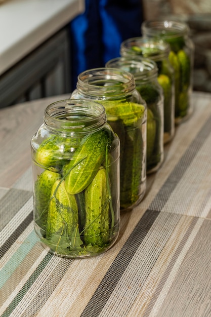 In glazen potten, ontbonden komkommers voor het koken van ingeblikt voedsel.