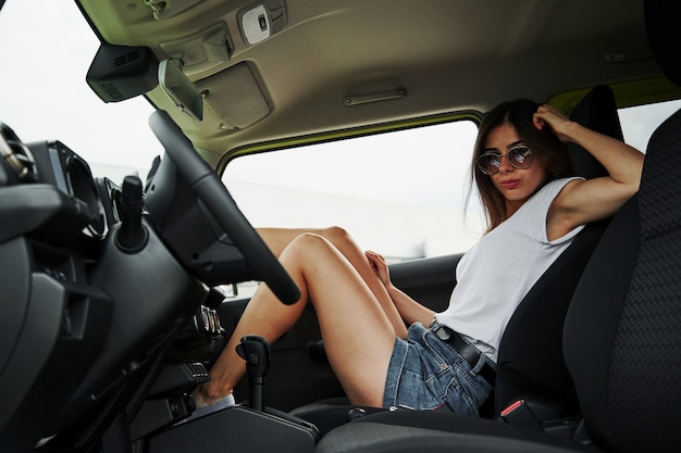 In het voertuig. mooie vrouw in de groene moderne auto poseren voor de camera.