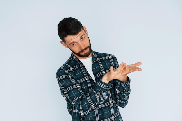 In in een geruit hemd Jonge man in vrijetijdskleding die binnenshuis in de studio staat