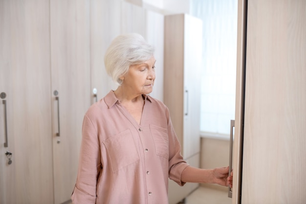 In kuuroord. Grijsharige rijpe vrouw in een kleedkamer in het kuuroord