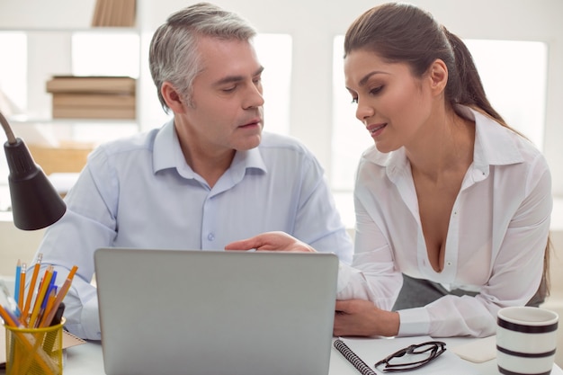 Inappropriate interest. pleasant attractive young woman sitting\
together with her male colleague and talking to his while being an\
object of inappropriate interest