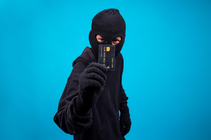 Foto inbreker met masker met creditcard op blauwe achtergrond